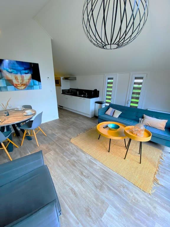 Moderne woonkamer met een zithoek, een eettafel en een open keuken, grote ramen met uitzicht naar buiten