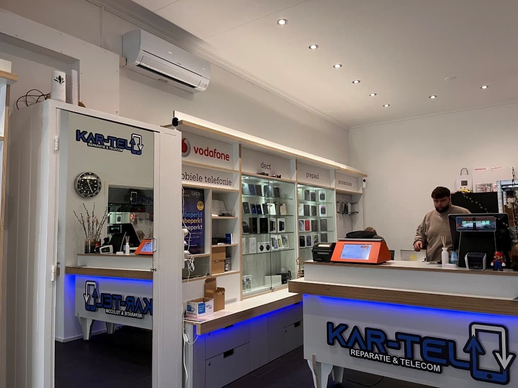 Interieur van een winkel met accessoires voor mobiele telefoons en een serviceteller, medewerkers aan het werk en displays ac