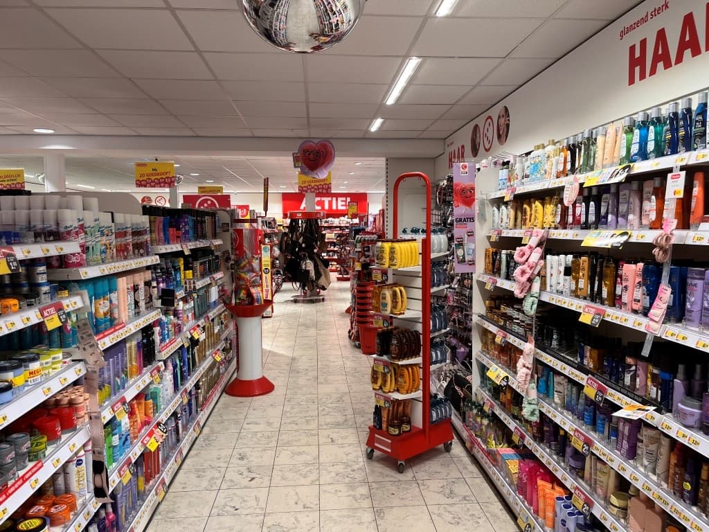 Interieur van een winkel met schappen vol verzorgingsproducten en een aantrekkelijke aanbieding in de voorgrond.