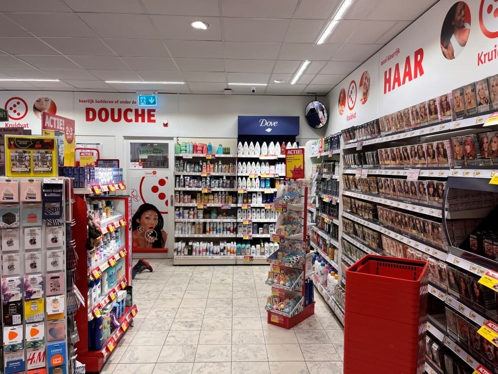 Winkelinterieur met schappen vol schoonheidsproducten en verzorgingsartikelen, verschillende promoties zichtbaar aan de wande