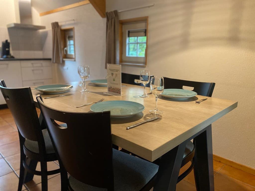 Eettafel met blauwe borden en glazen in een gezellige eetruimte met lichte muren en houten details