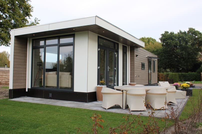 Moderne vakantiewoning met grote ramen, een terras en tuinmeubilair op Camping De Konijnenberg in Harderwijk