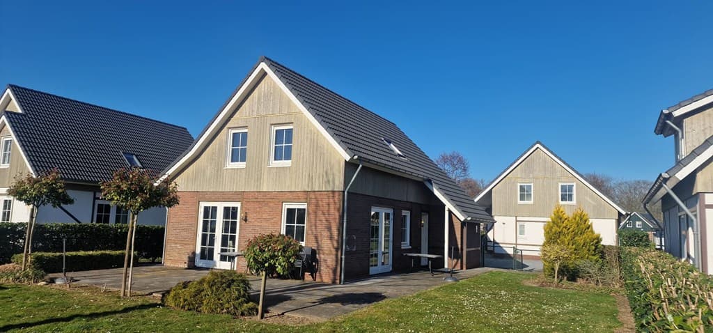 Zijdelings aanzicht van een vakantiewoning met tuin en terras, gelegen op EuroParcs Limburg in Susteren.