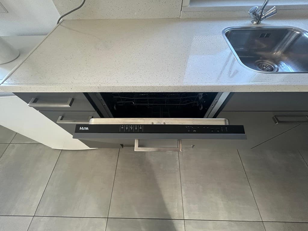 Moderne keuken met een open laadkast en een metalen spoelbak met een glanzend aanrechtblad.