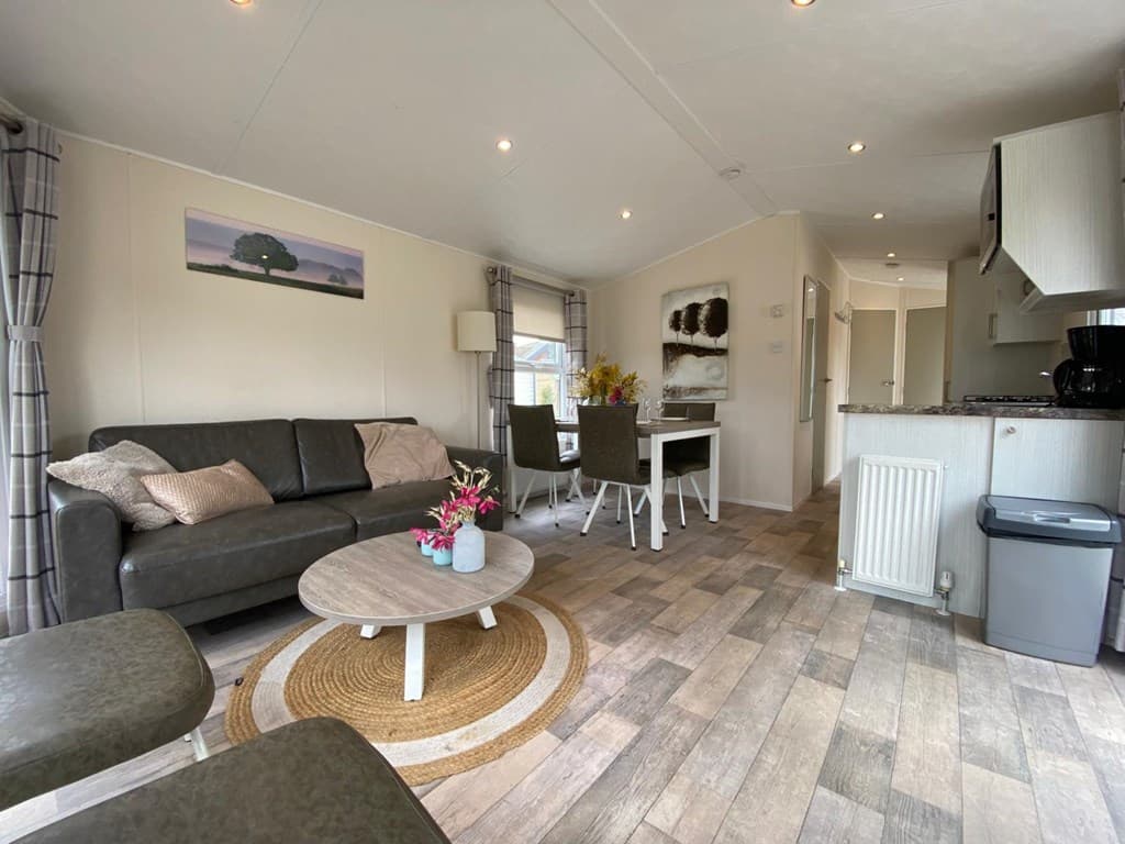 Moderne woonkamer met zithoek, eethoek en open keuken in een vakantiewoning.