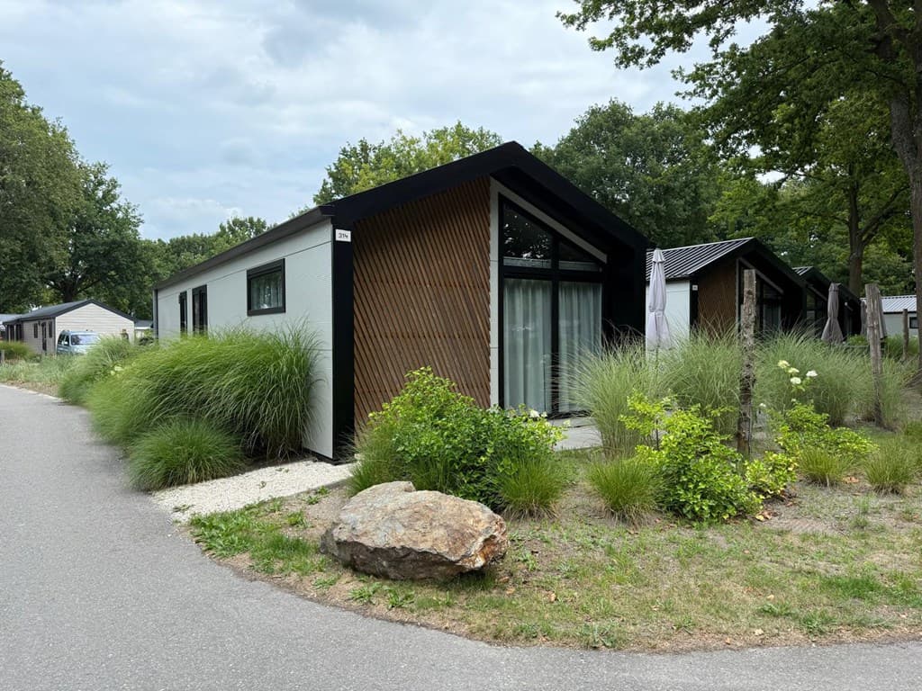 Moderne vakantiewoning met houten gevel, omringd door groen en gelegen aan een verharde weg in EuroParcs Kaatsheuvel