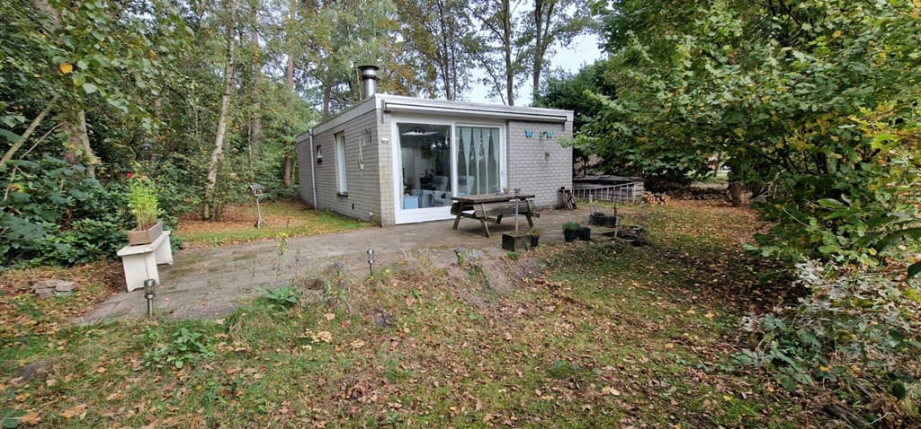Vakantiehuisje omringd door groen met terras en grote ramen in RCN Vakantiepark de Flaasbloem, Chaam