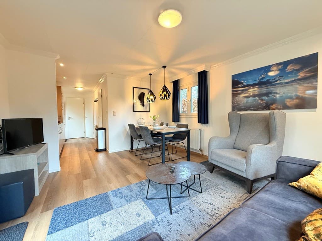 Hedendaagse woonkamer met zitgedeelte, eettafel, televisie en moderne verlichting