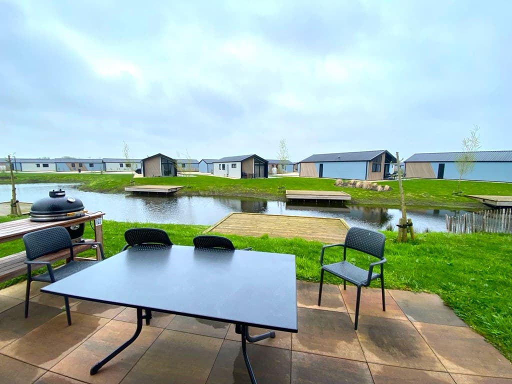 Uitzicht op een waterpartij met houten aanlegplaatsen en vakantiehuizen op EuroParcs De IJssel Eilanden in Kampen