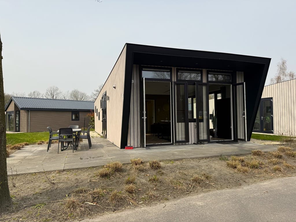 Moderne vakantiewoning met een schuine daklijn, terras met tuinmeubelen en groene omgeving in EuroParcs Kaatsheuvel.