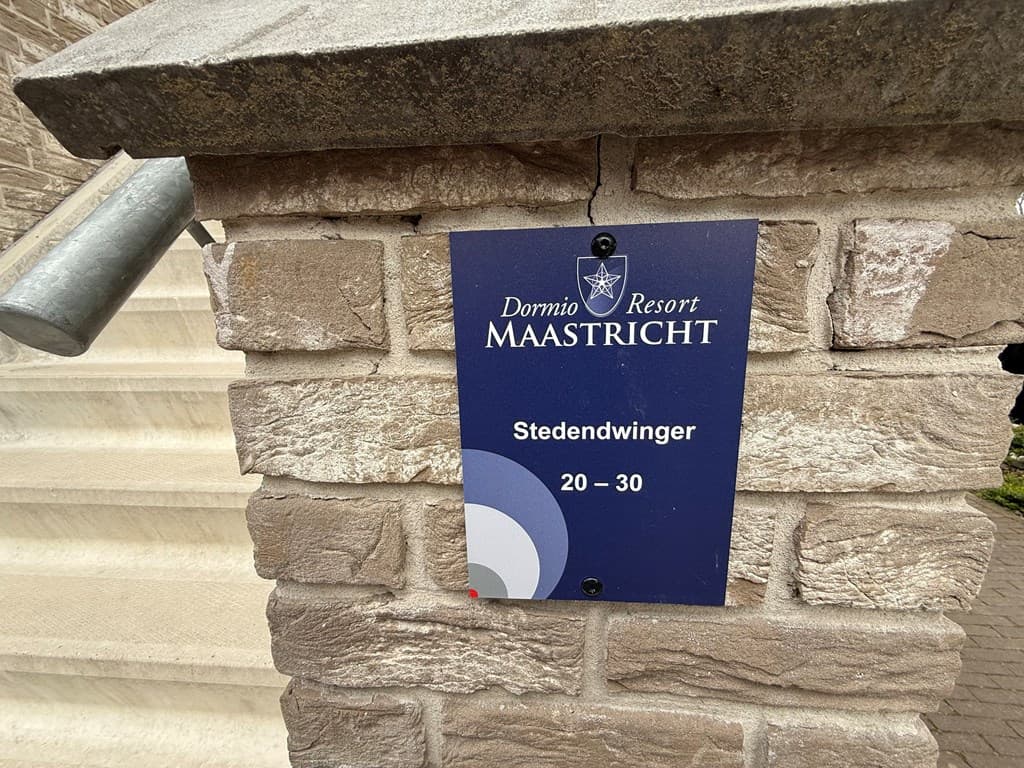 Informatiebord van Dormio Resort Maastricht bij de trap met de naam Stedenwinger en huisnummers 20-30.