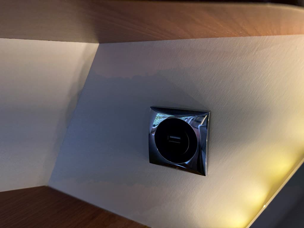 Een close-up van een wandcontactdoos met een USB-aansluiting in een hoek van een kamer