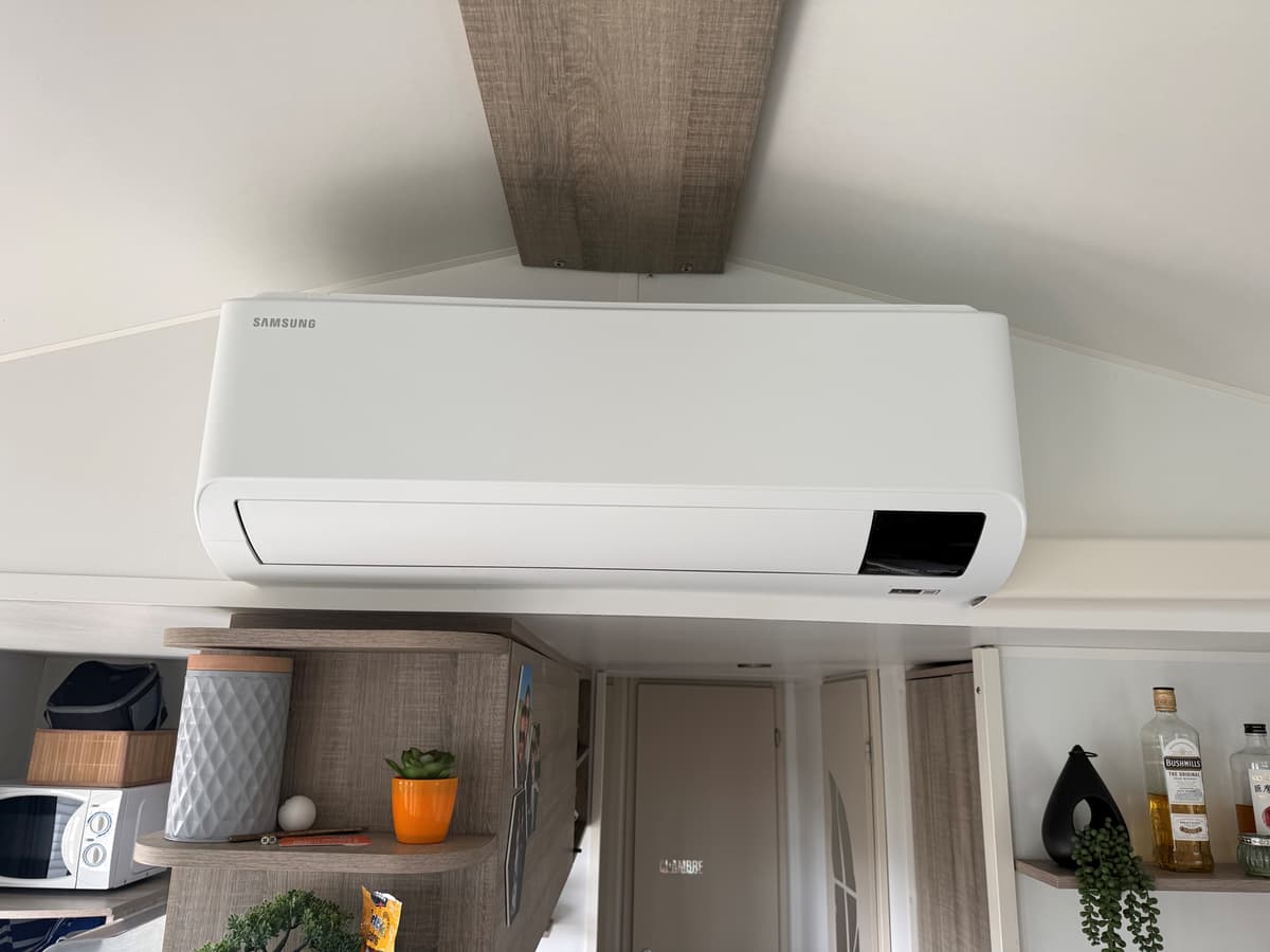 Luchtbehandelingssysteem aan het plafond in een moderne woonruimte met houten details en decoratieve elementen.