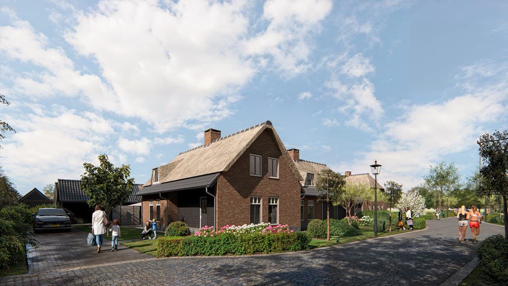 Moderne woning met bakstenen gevel en twee daken, omgeven door groen en bloeiende planten langs een klinkerweg.