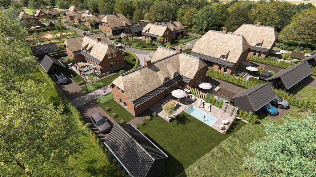 Luchtfoto van een nieuwbouwproject met woningen, groen percelen en auto's op de opritten