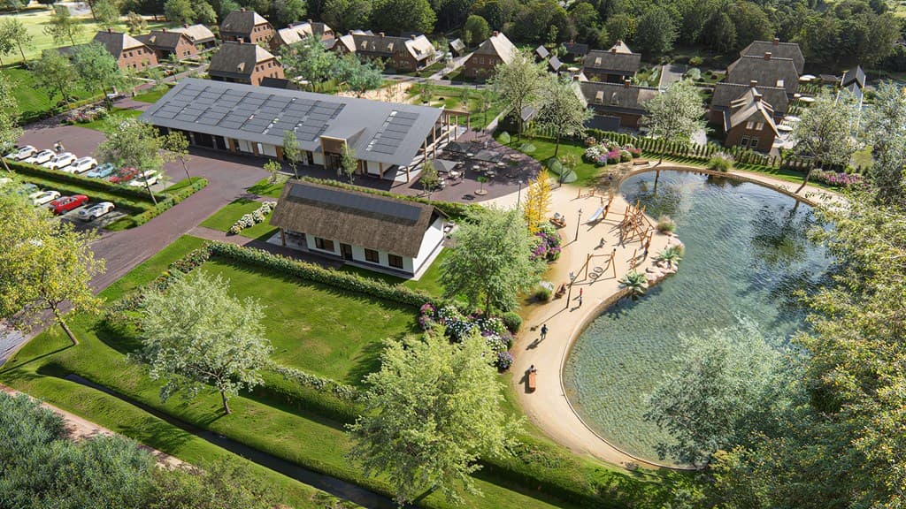 Uitzicht op een moderne woning met rieten dak omringd door groen, een waterpartij en meerdere vakantiewoningen in de omgeving