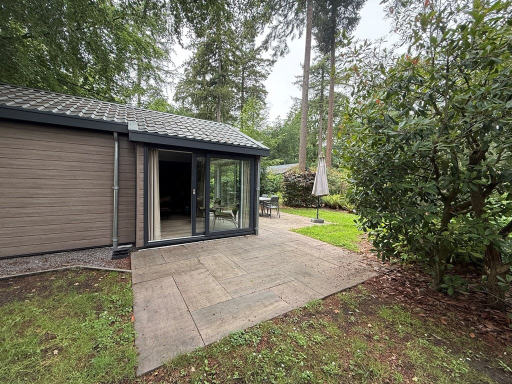 Moderne vakantiewoning met stijlvolle buitenterrassen en groene uitstraling in een bosrijke omgeving