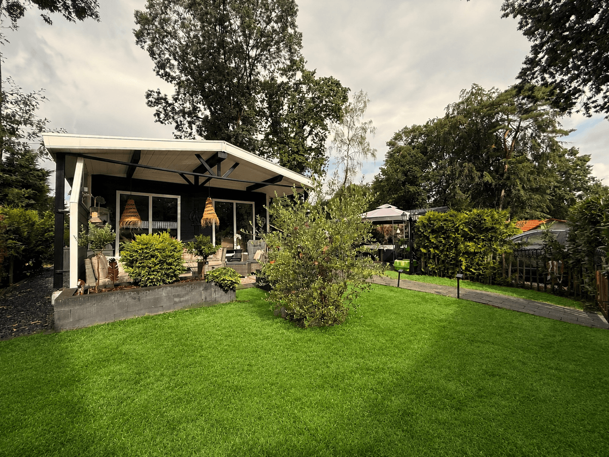 Recreatiewoning met een ruime groene tuin, terras met overkapping en omliggend hekwerk op Camping De Konijnenberg.