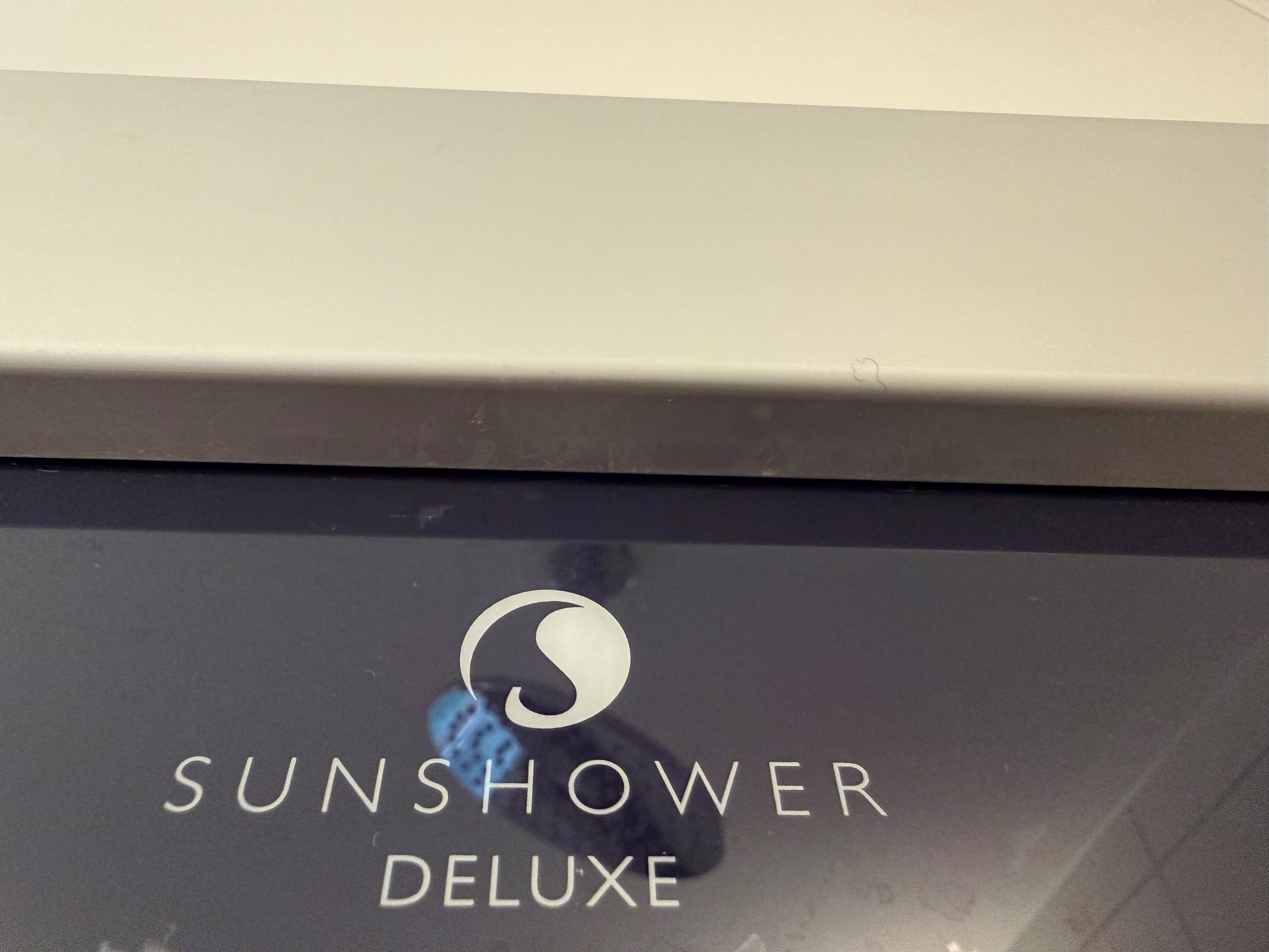 Detail van een Sunshower Deluxe, zichtbaar zijn de naam en het logo op een glanzend oppervlak