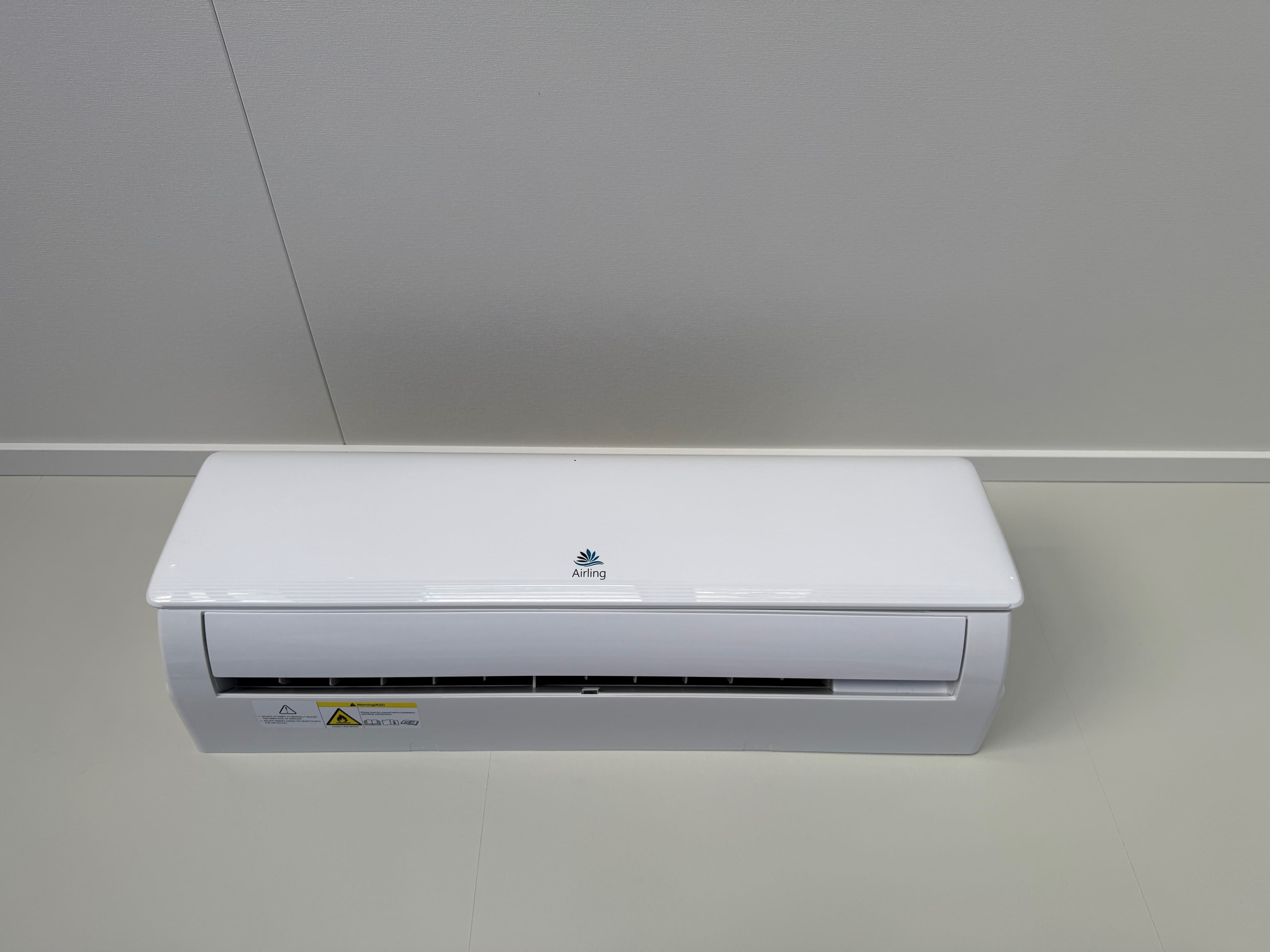 Witte wandunit voor airconditioning op een lichte muur met een neutrale ondergrond