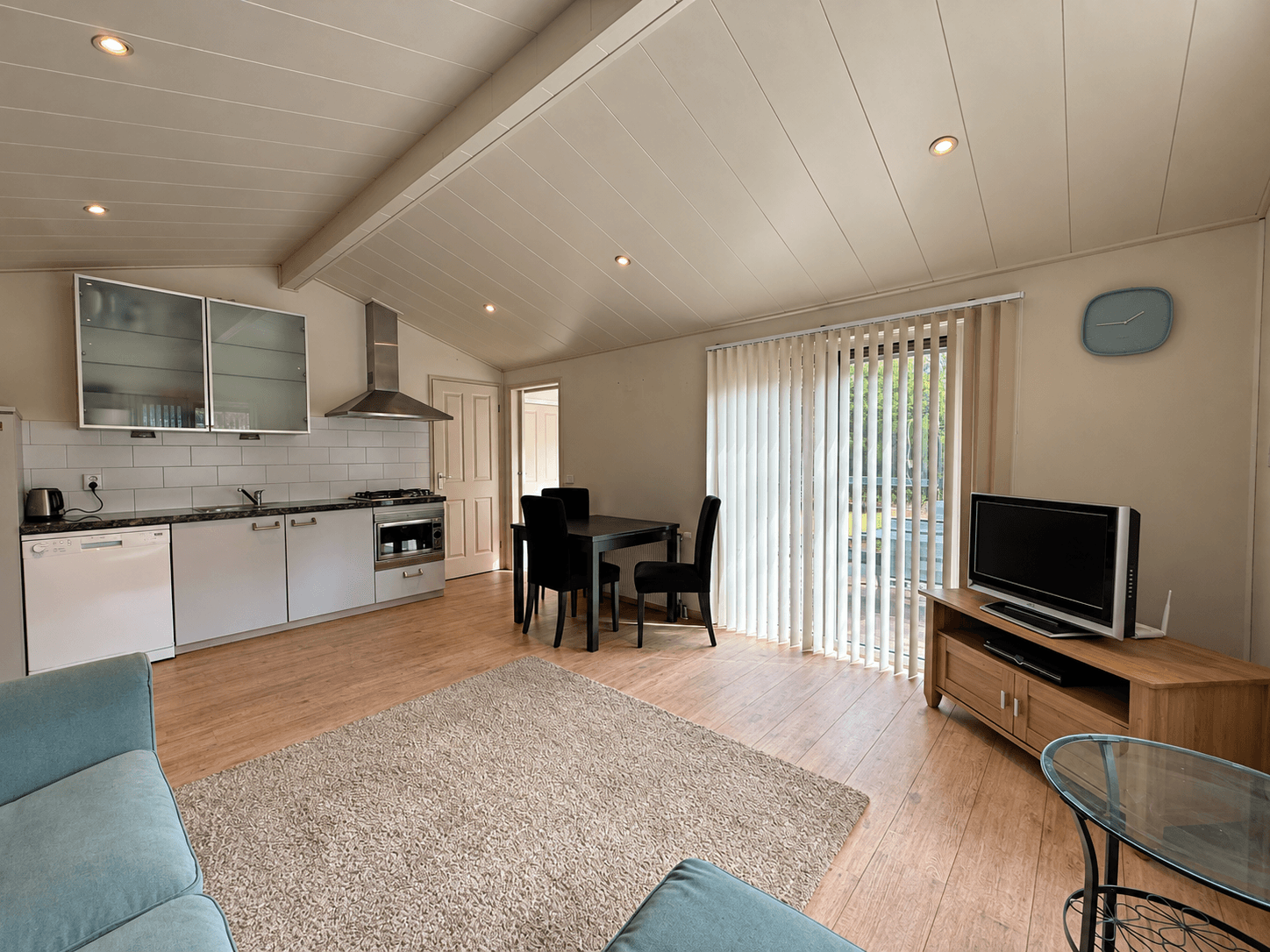 Open woonkamer met keuken, eettafel, zithoek en schuifdeur naar de buitenruimte met veel natuurlijk licht