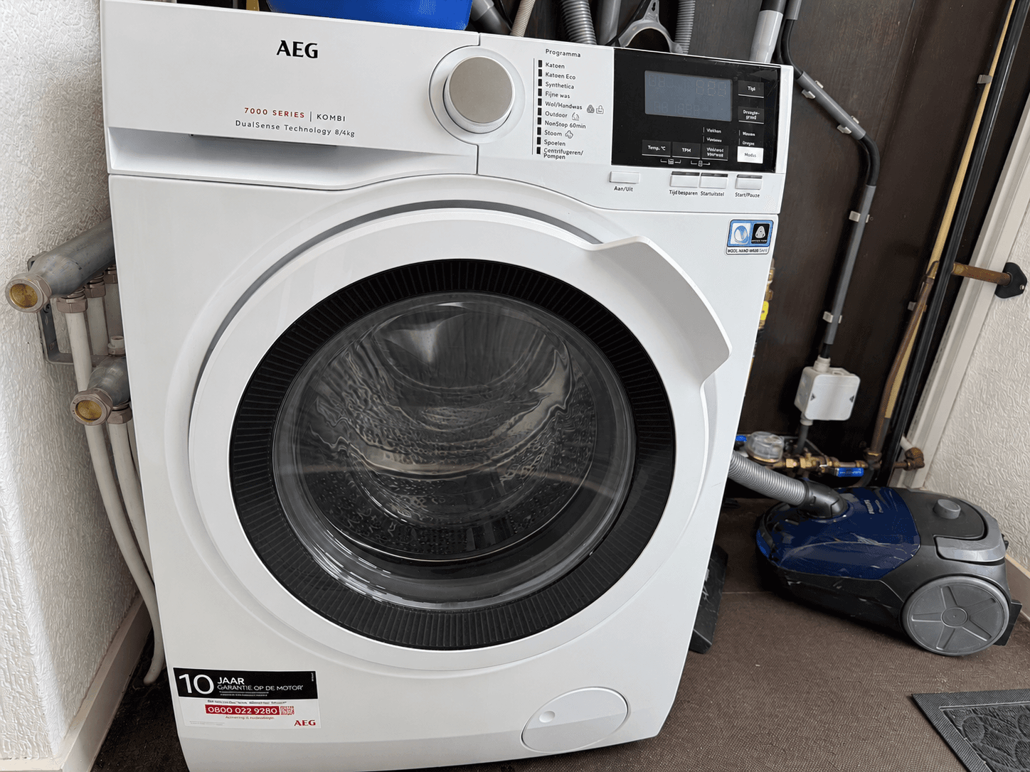 Wasmachine van het merk AEG met een duidelijk zichtbare deur en bedieningspaneel in een moderne ruimte