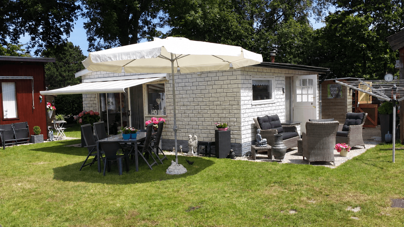 Recreatiewoning met terrasmeubilair, parasol en groene tuin in Molecaten Park Kruininger Gors, Oostvoorne