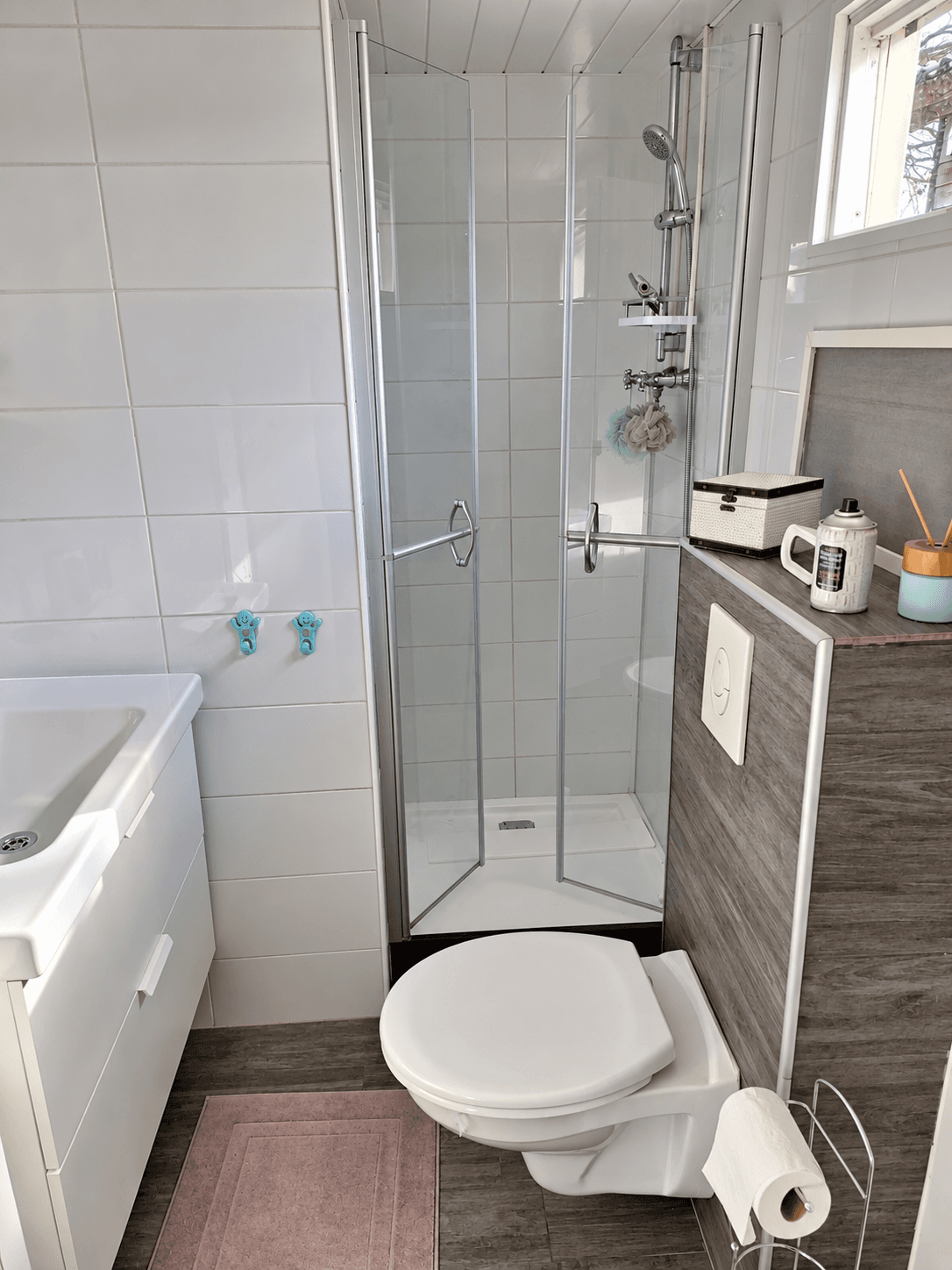 Badkamer met douchecabine, toilet en wastafel, lichte tegels en moderne afwerking