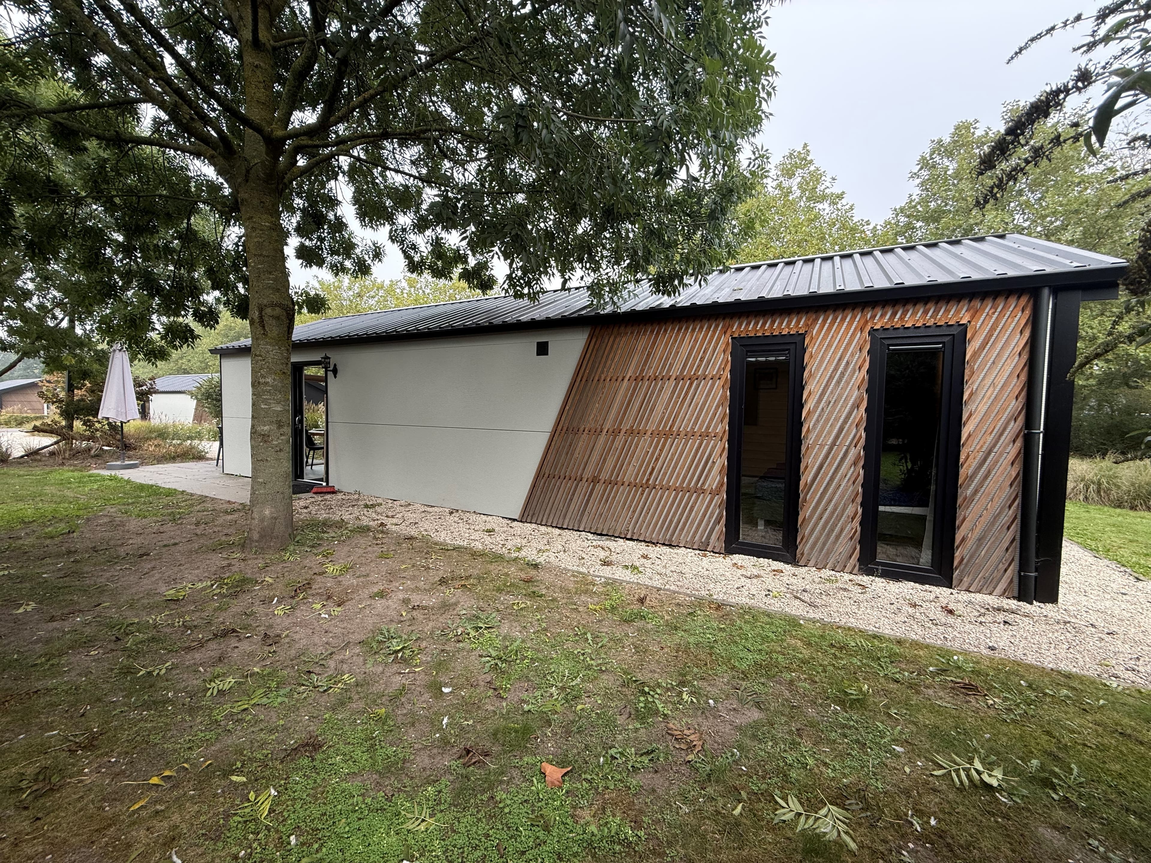 Moderne vakantiewoning met houten gevel, gelaagd dak en groene omgeving in EuroParcs Kaatsheuvel.