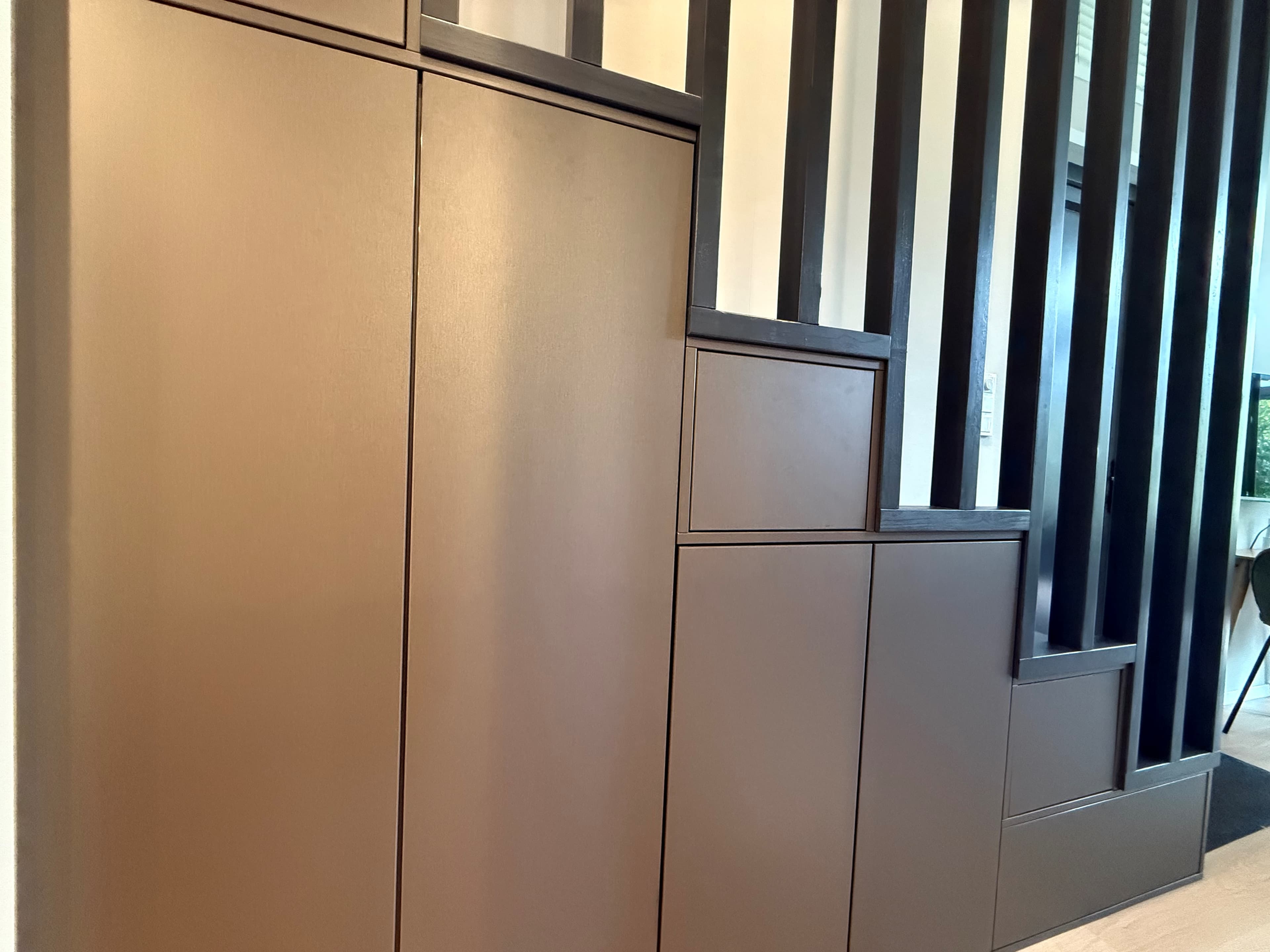 Moderne trap met opbergruimte, omringd door strakke zwarte verticale latten in de recreatiewoning.