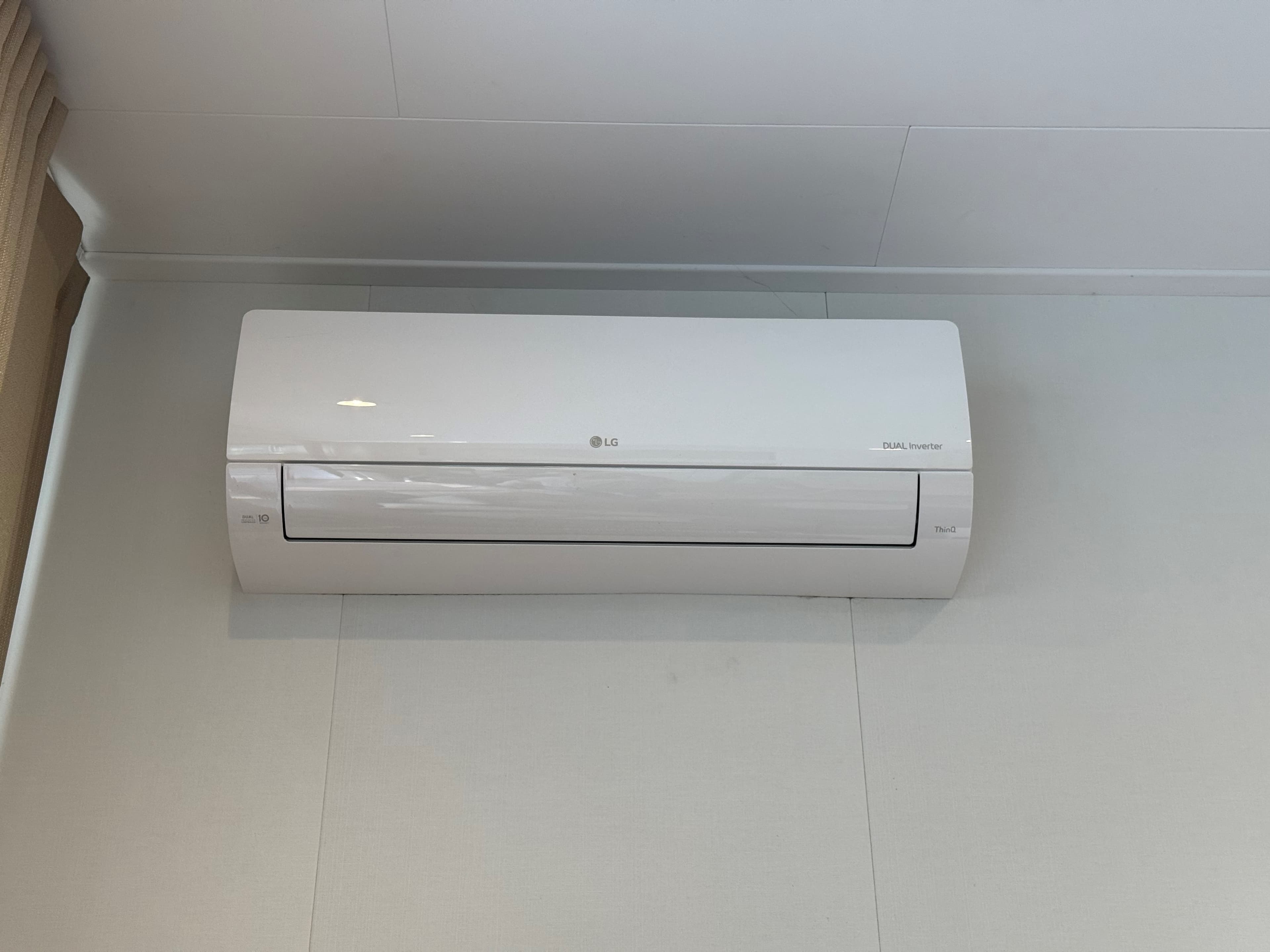 Witte airconditioningseenheid aan de muur in een lichte ruimte