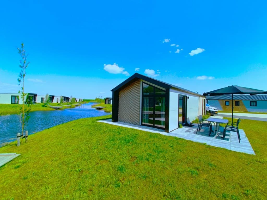 Moderne vakantiewoning met glazen wand en terras, gelegen aan een waterpartij in EuroParcs De IJssel Eilanden, Kampen.
