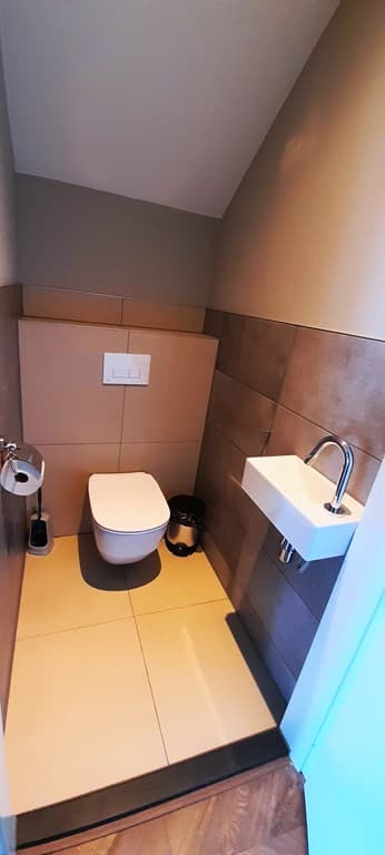 Toilet met wandcloset en fonteintje, tegels in aardetinten en moderne afwerking