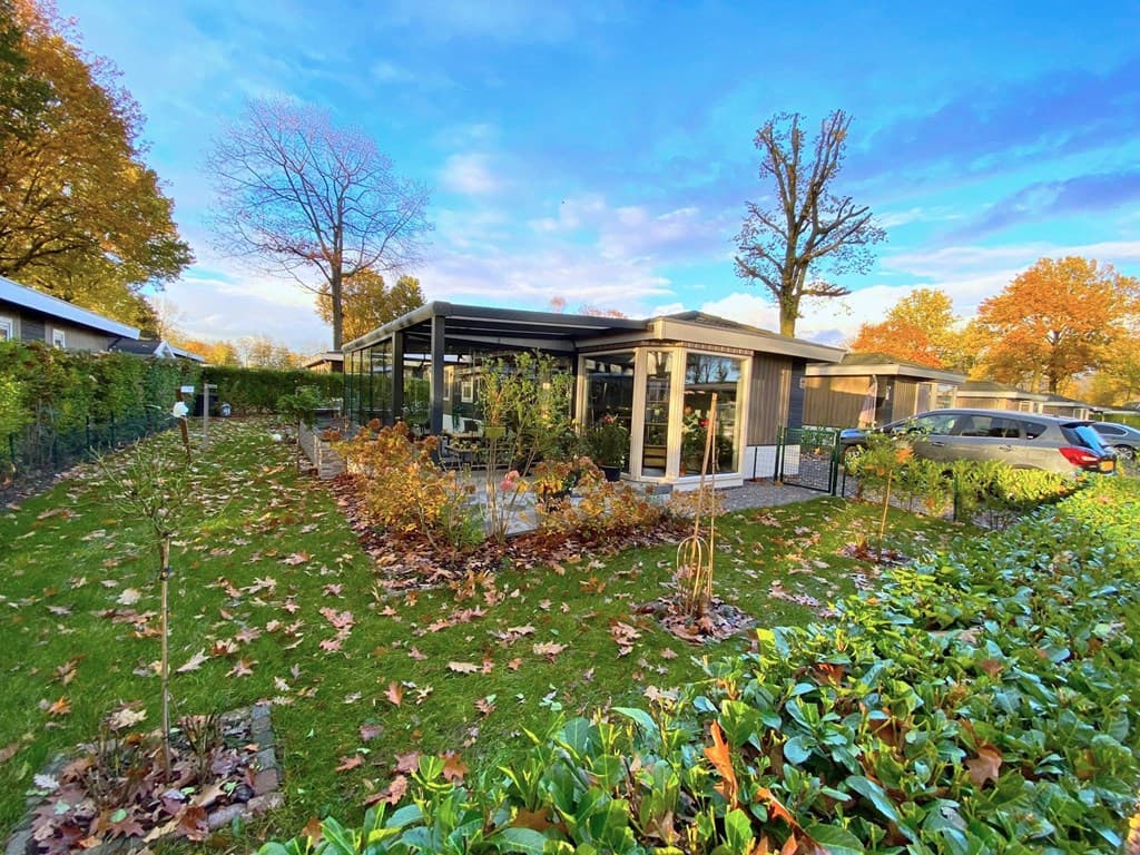 Moderne vakantiewoning met overdekte veranda en groene tuin met herfstbladeren in EuroParcs Limburg, Susteren