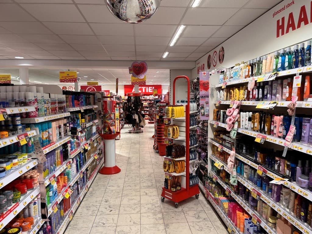 Interieur van een winkel met schappen vol verzorgingsproducten en een aantrekkelijke aanbieding in de voorgrond.