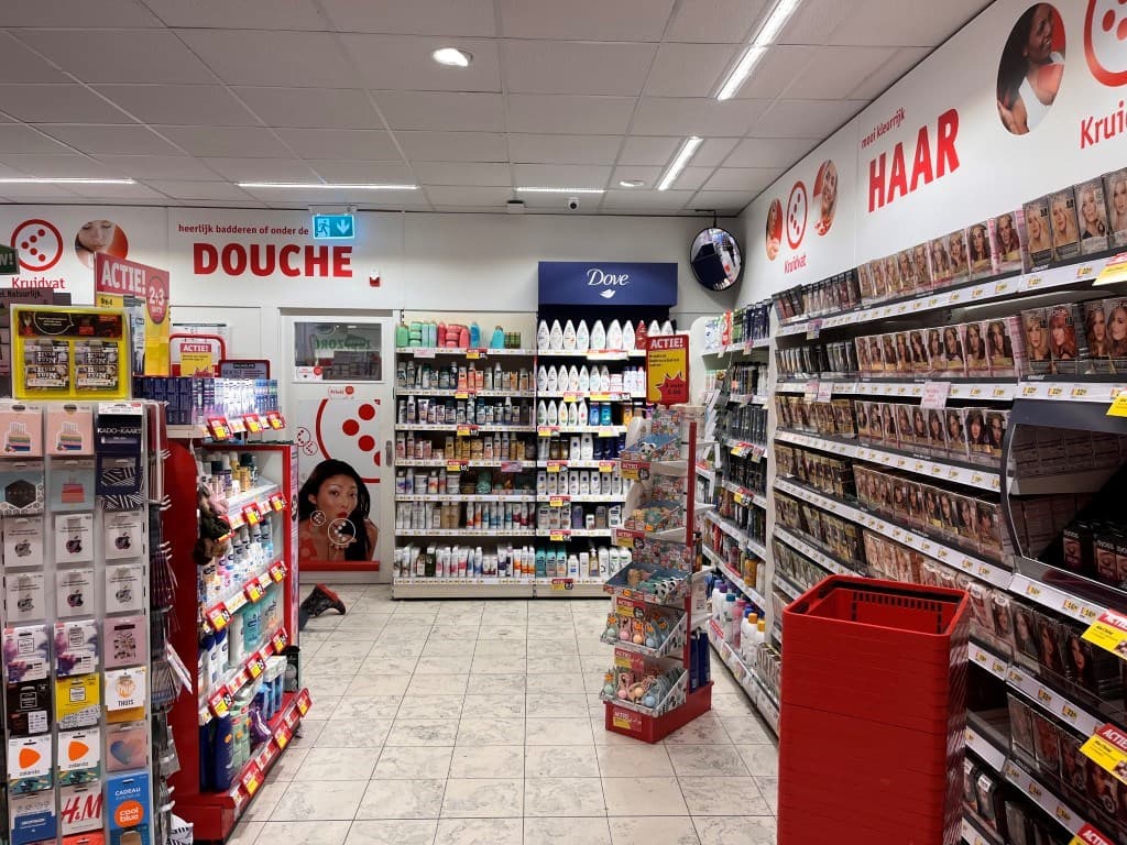 Winkelinterieur met schappen vol schoonheidsproducten en verzorgingsartikelen, verschillende promoties zichtbaar aan de wande