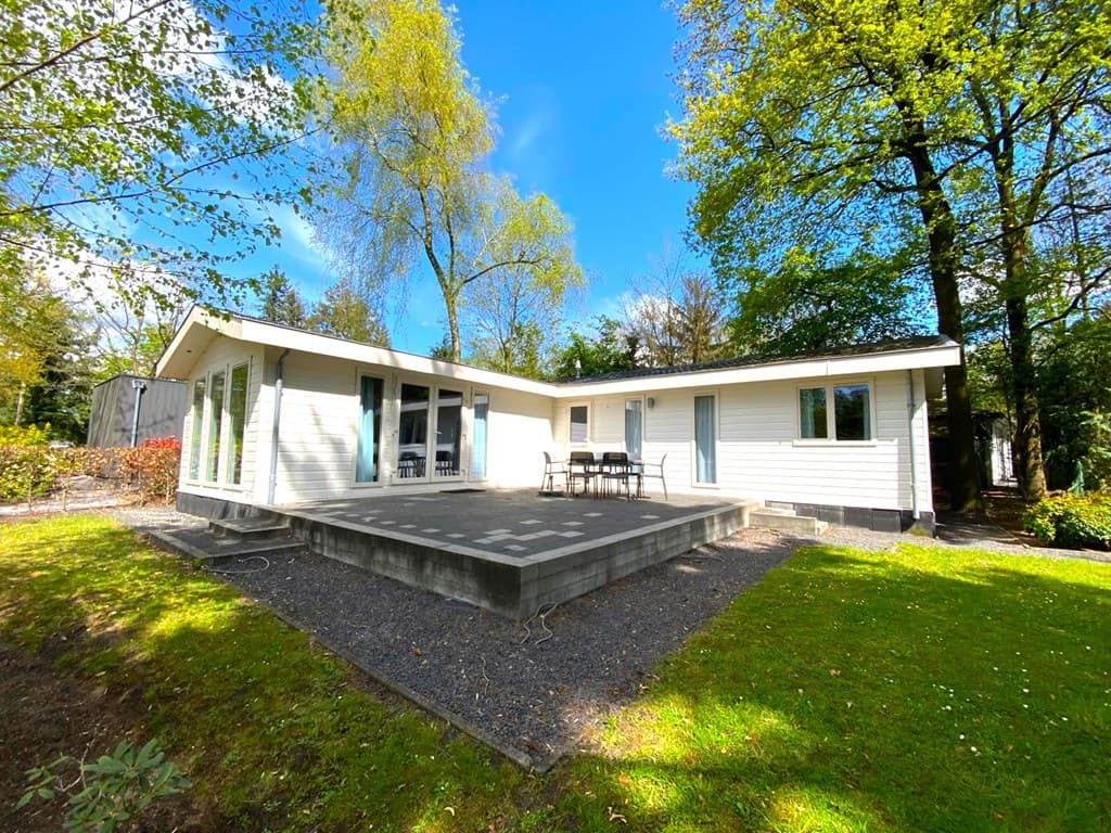 Moderne vakantiewoning met ruime veranda, omringd door groen en bomen op EuroParcs De Achterhoek