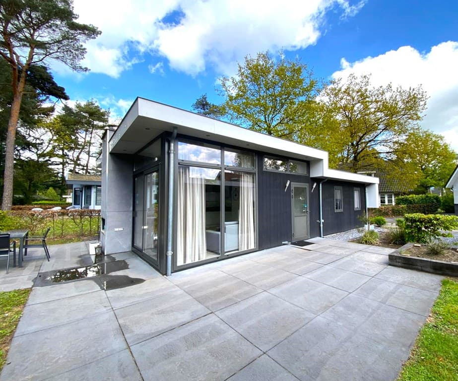 Moderne vakantiewoning met grote ramen, terras en aangelegde tuin bij EuroParcs De Achterhoek in Lochem