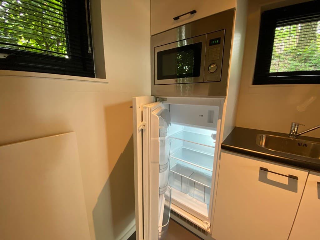 Ingebouwde koel-vriescombinatie met een moderne uitstraling en een gootsteen in de keuken.