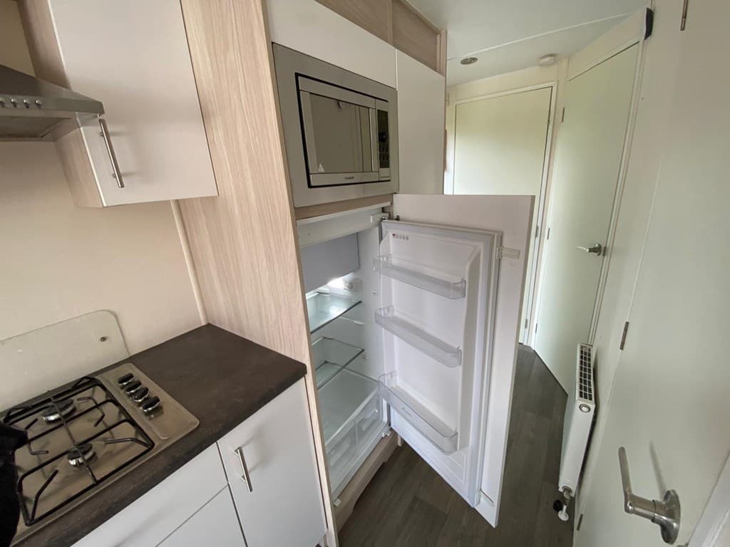 Keuken met open koelkast, gasfornuis en moderne keukenkastjes in EuroParcs Zuiderzee, Biddinghuizen