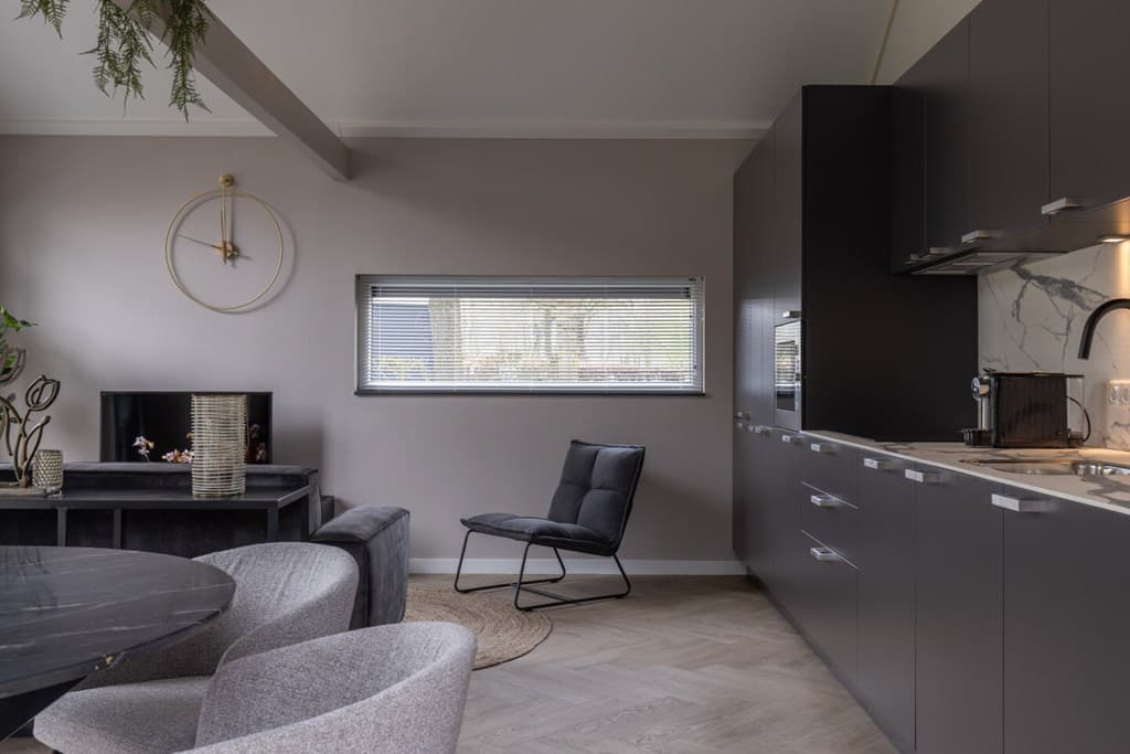 Interieur van een vakantiehuis met een moderne keuken, zithoek en eettafel in een neutrale kleurenpalet