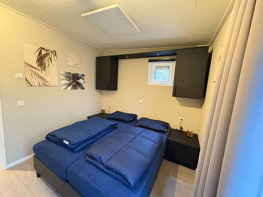 Sfeervolle slaapkamer met twee eenpersoonsbedden, kast, raam en moderne wanddecoratie