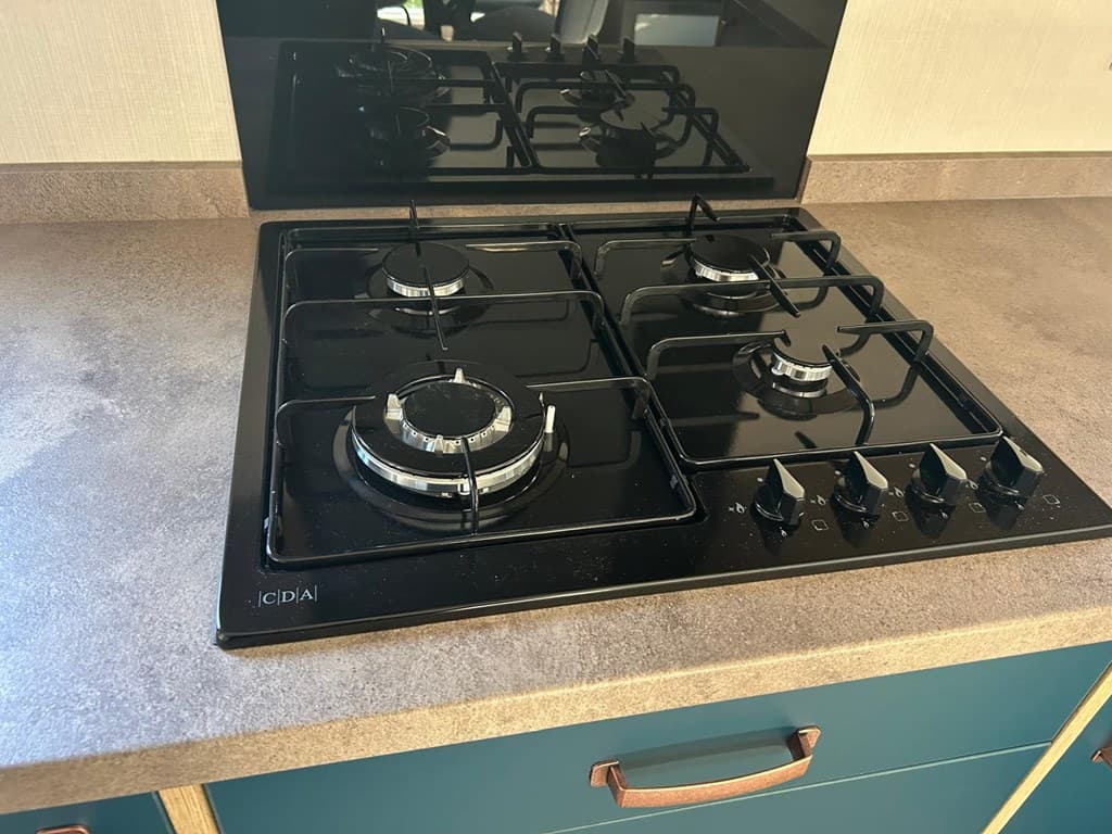 Gasfornuis met vier branders op een aanrechtblad in een moderne keuken.