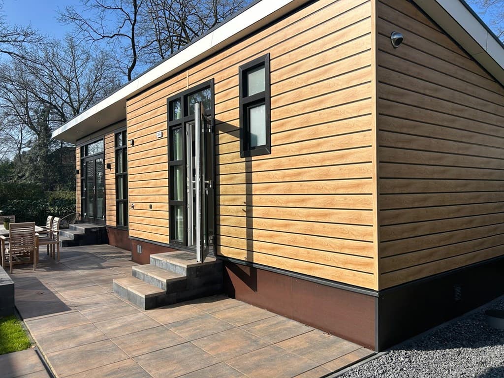 Moderne vakantiewoning met houten gevel en grote ramen, gelegen op Camping De Konijnenberg in Harderwijk.