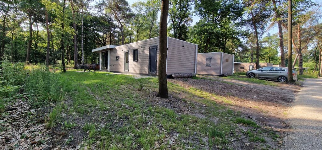Moderne vakantiewoning in een bosrijke omgeving met parkeerplek en naastgelegen huisjes