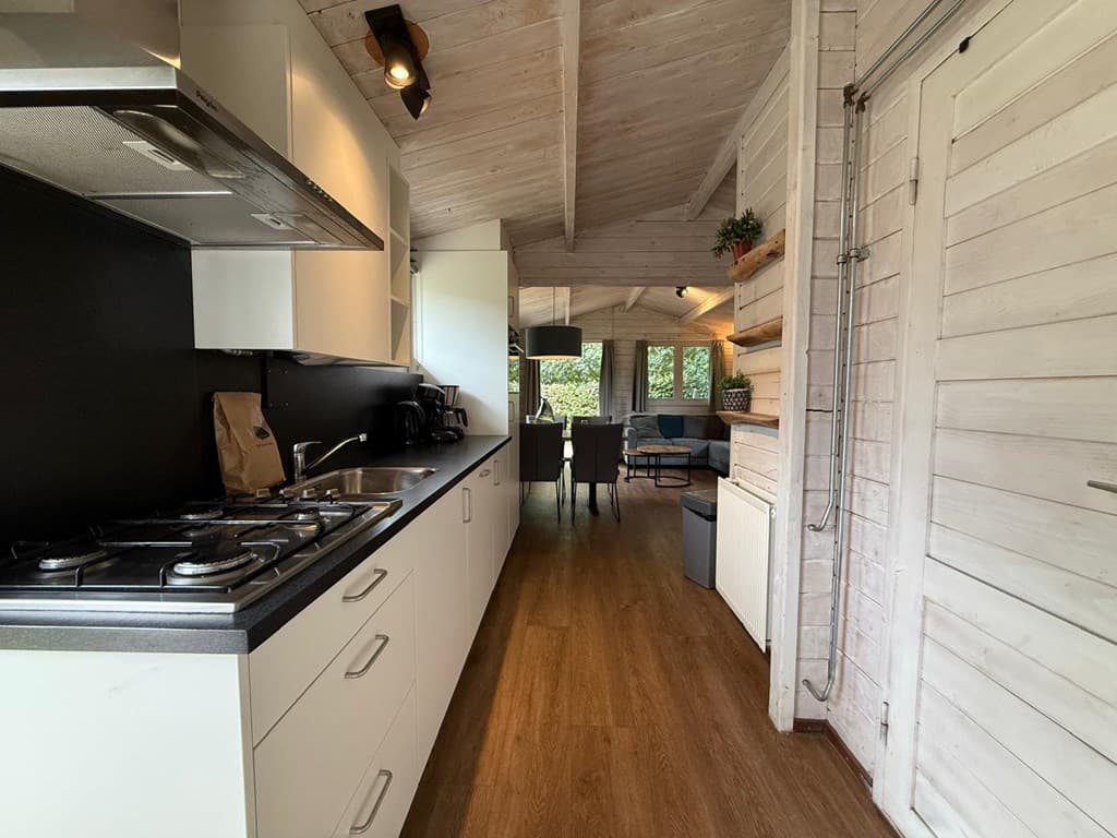 Keuken met moderne inrichting en open verbinding naar de zithoek en eetruimte in een vakantiehuis.