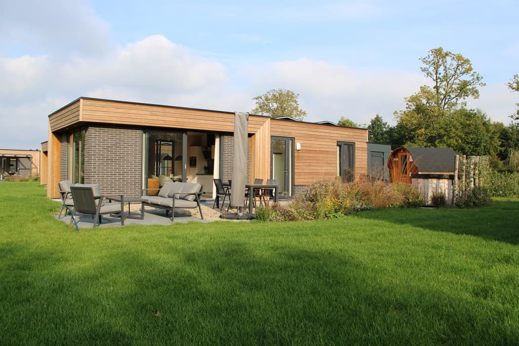 Moderne vakantiewoning met houten gevel, ruime tuin en zitgedeelte op net grasveld in Vakantiepark Hofparken Wiltershaar.