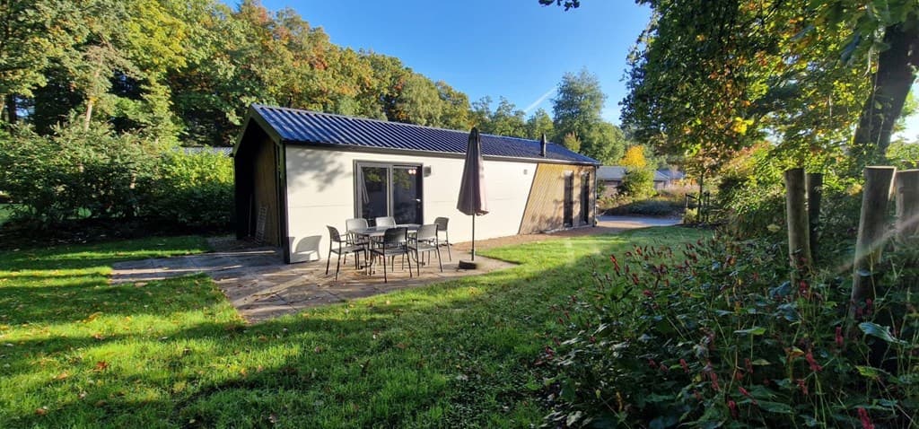 Moderne vakantiewoning met terras en tuinmeubilair, omgeven door groen op EuroParcs Resort De Utrechtse Heuvelrug.