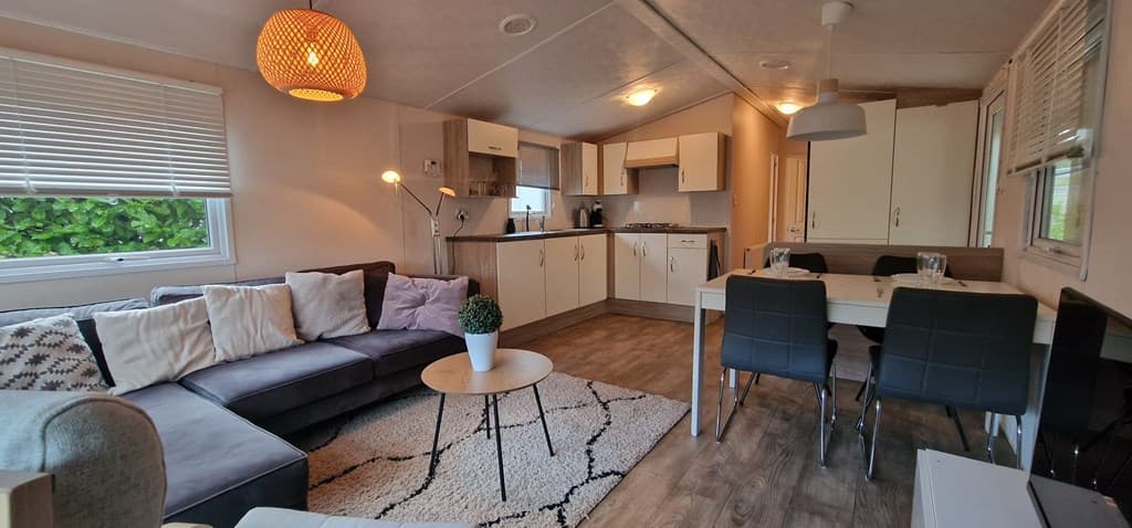 Gezellige woonkamer met zithoek, eettafel en moderne keuken in een vakantiehuisje