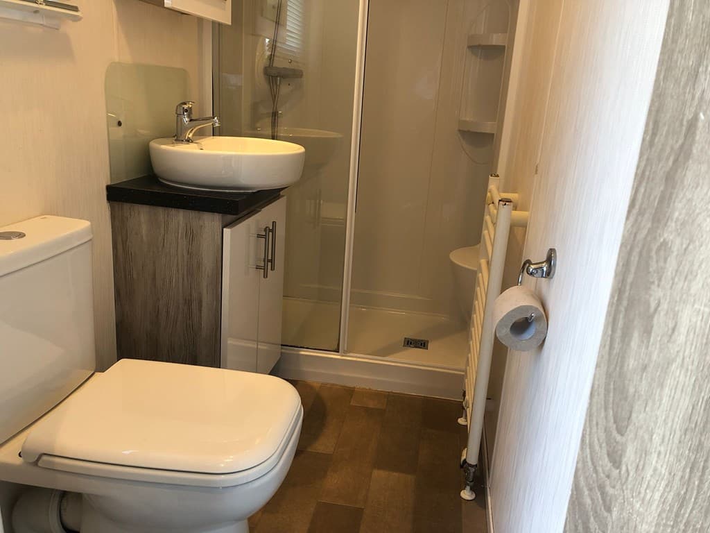 Badkamer met toilet, wastafel en douchecabine, lichte wanden en moderne afwerking
